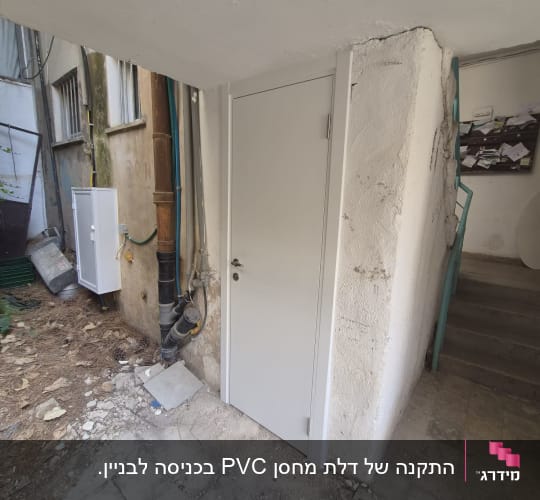 דלת פלדה אפורה חדשה מותקנת בכניסה למבנה מגורים